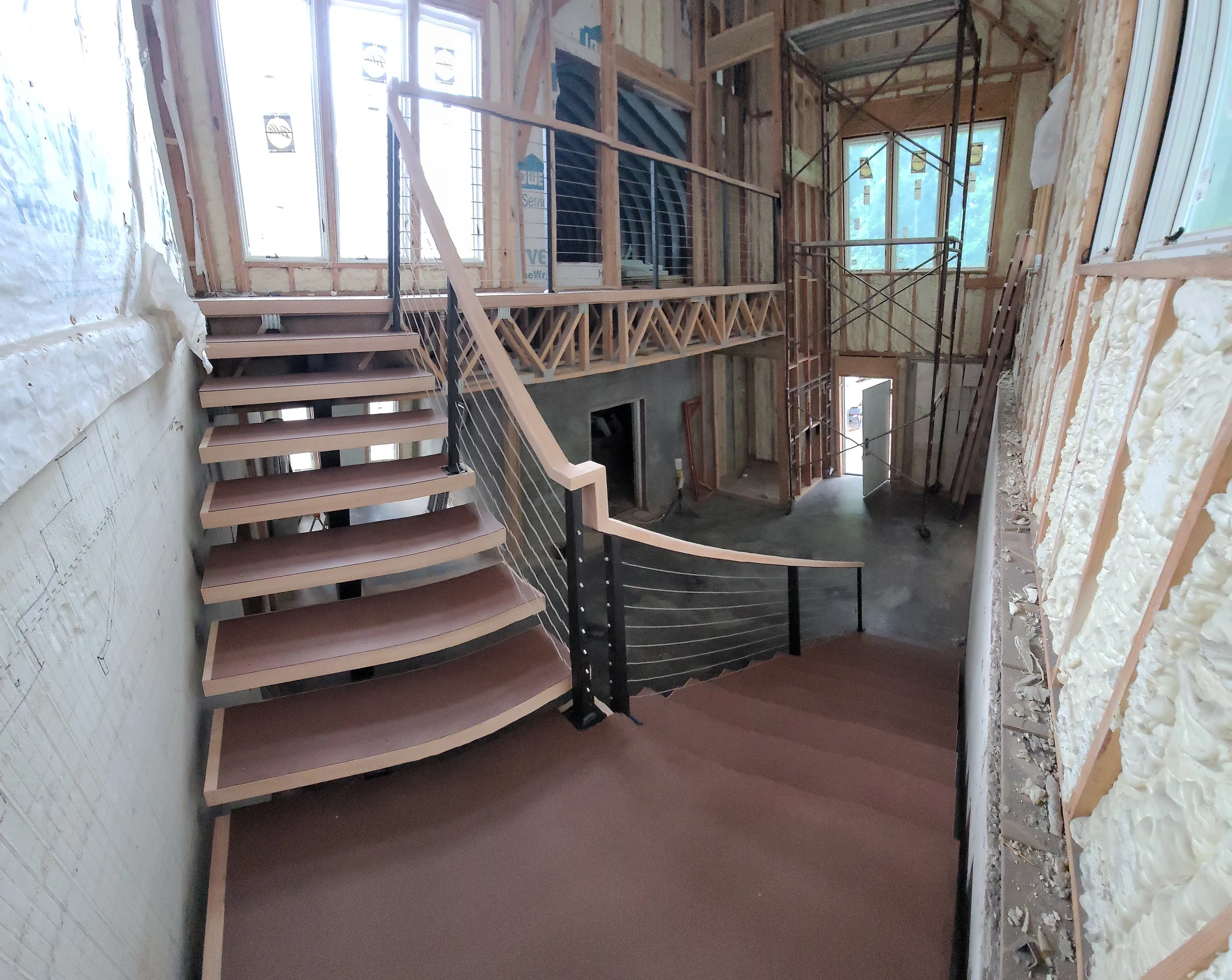 Looking up at the floating stair treads and cable rail.