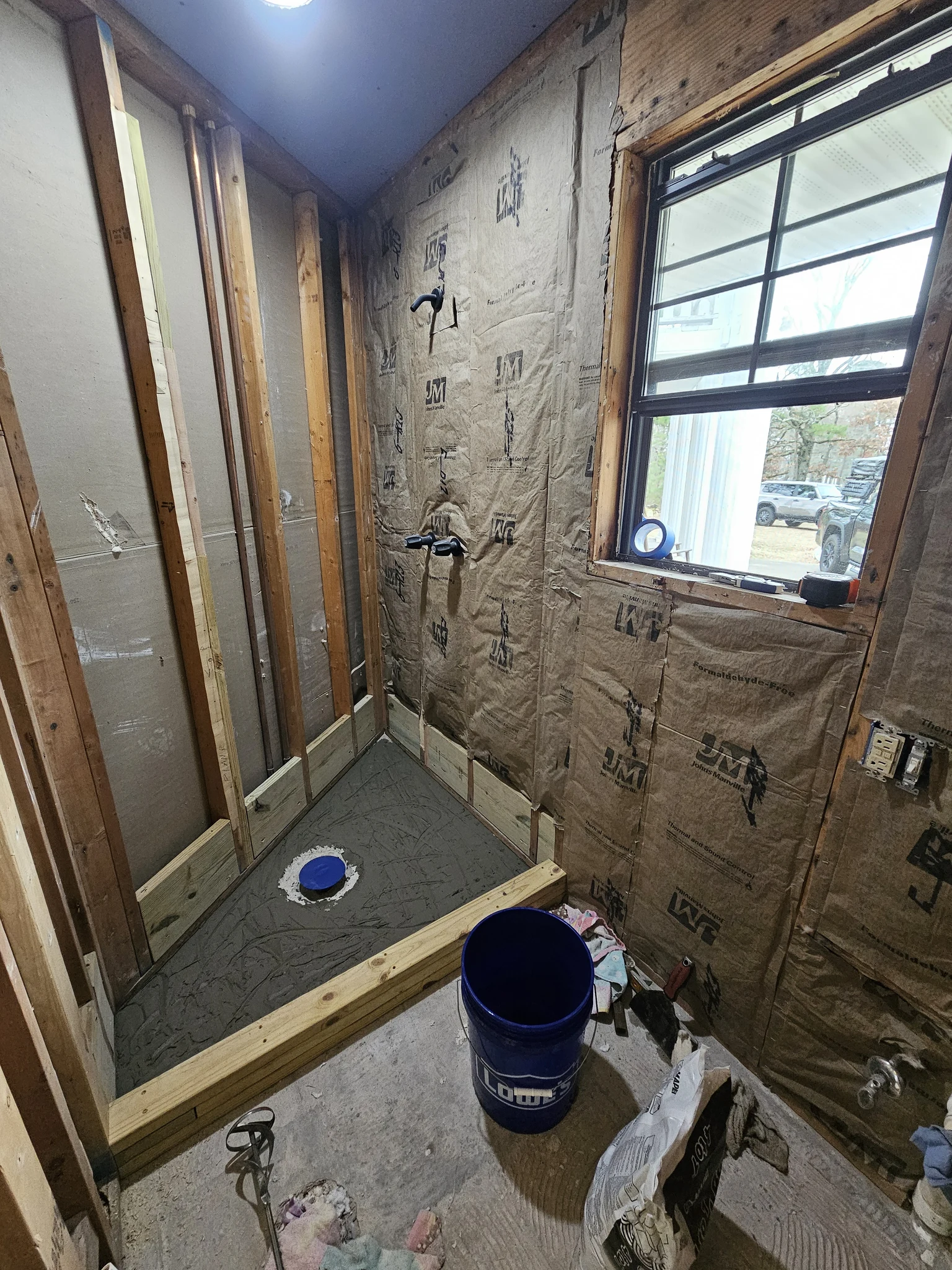 The bathroom with insulation installed and blocking framed for the shower.