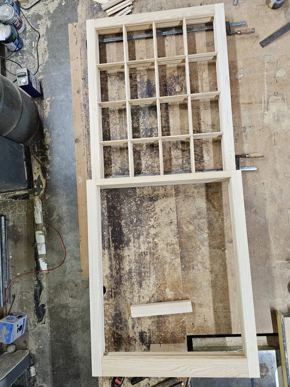 The full sixteen-light sash frame laid out flat on the workbench.