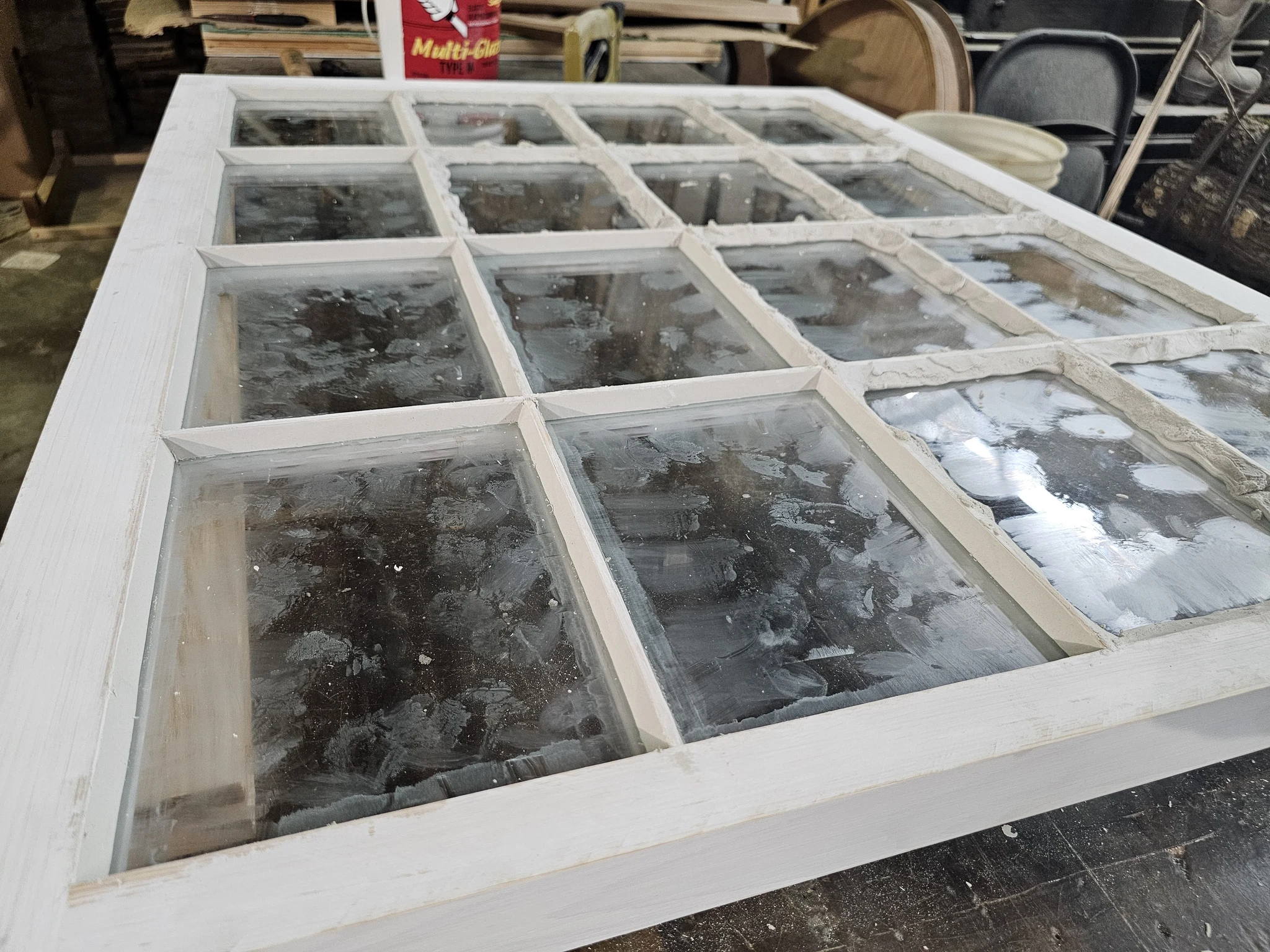 Glass set into the sash with glazing compound being bedded by hand.