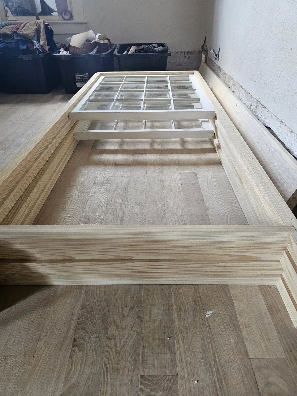 Finished primed sashes resting on a floor, ready for delivery to site.