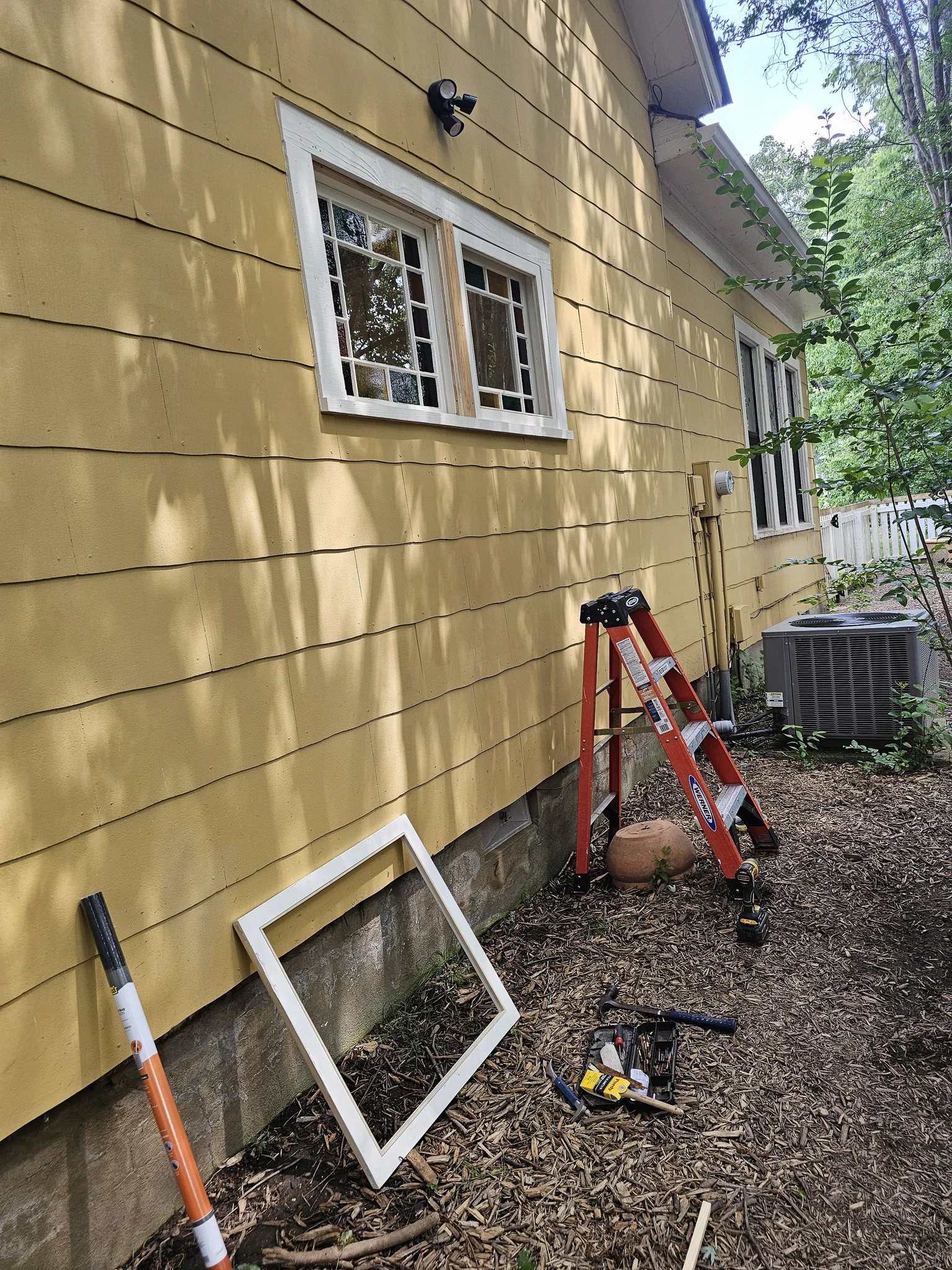The exterior wall with the window opening and tools during reinstallation.