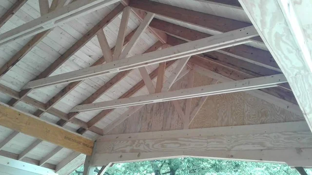 Underside view of the carport rafter framing and decorative rafter ties.