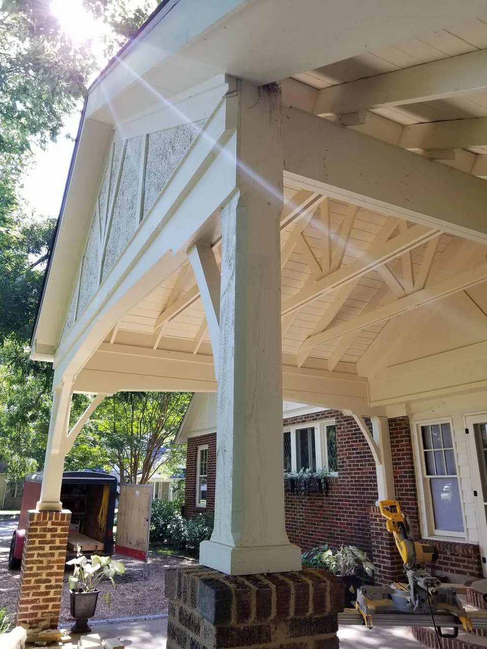 The completed carport shot upward into the gable with sun flare.