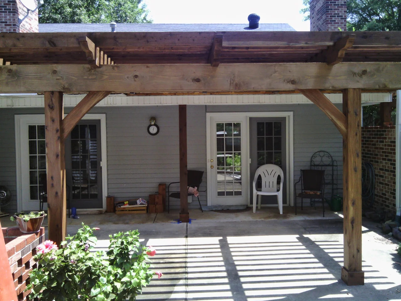 The pergola casting striped shadows across the patio.
